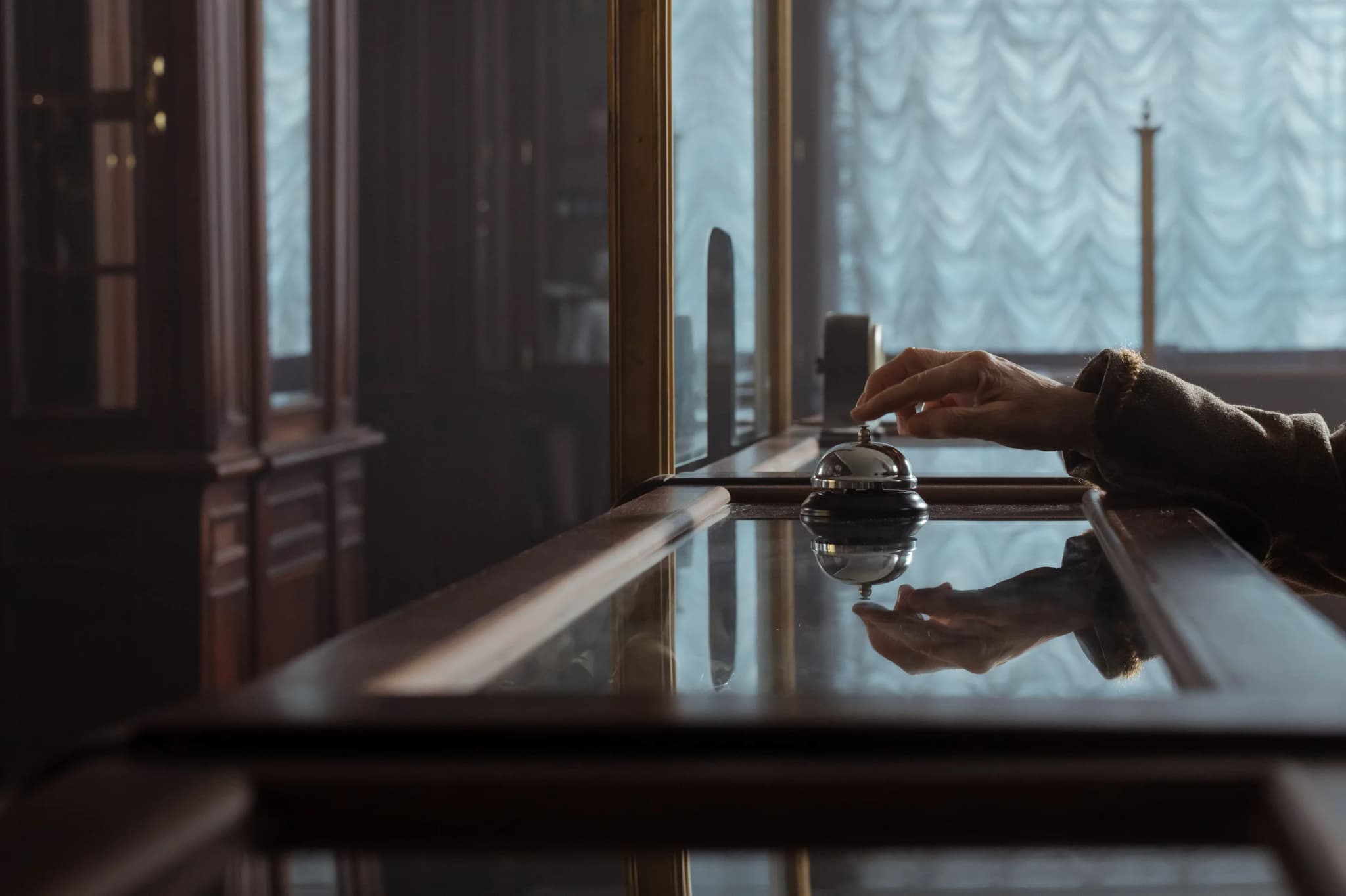 Guest ringing the reception service bell at a GHD Hotels front desk