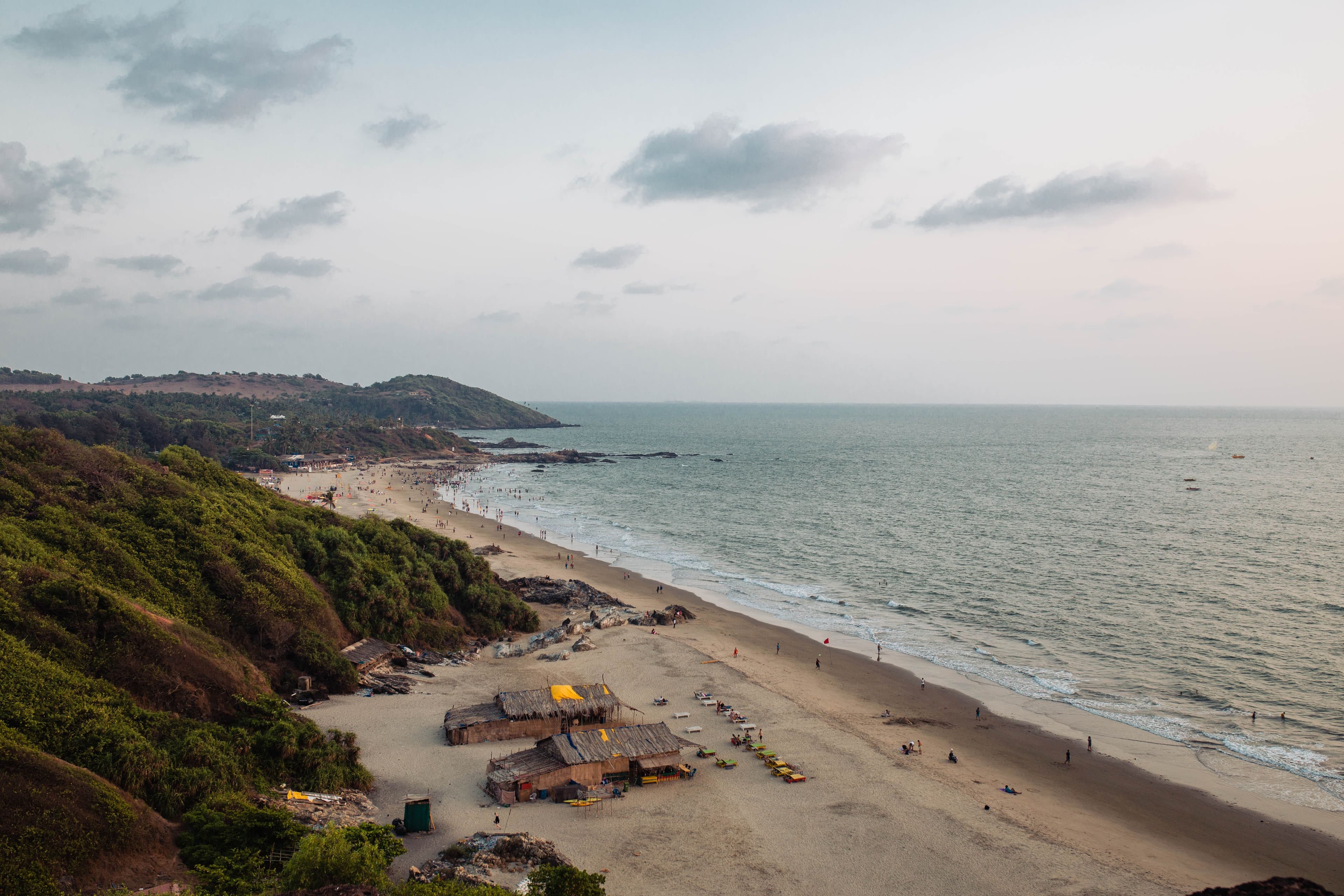 Scenic Goan beach with lush hills and gentle waves
