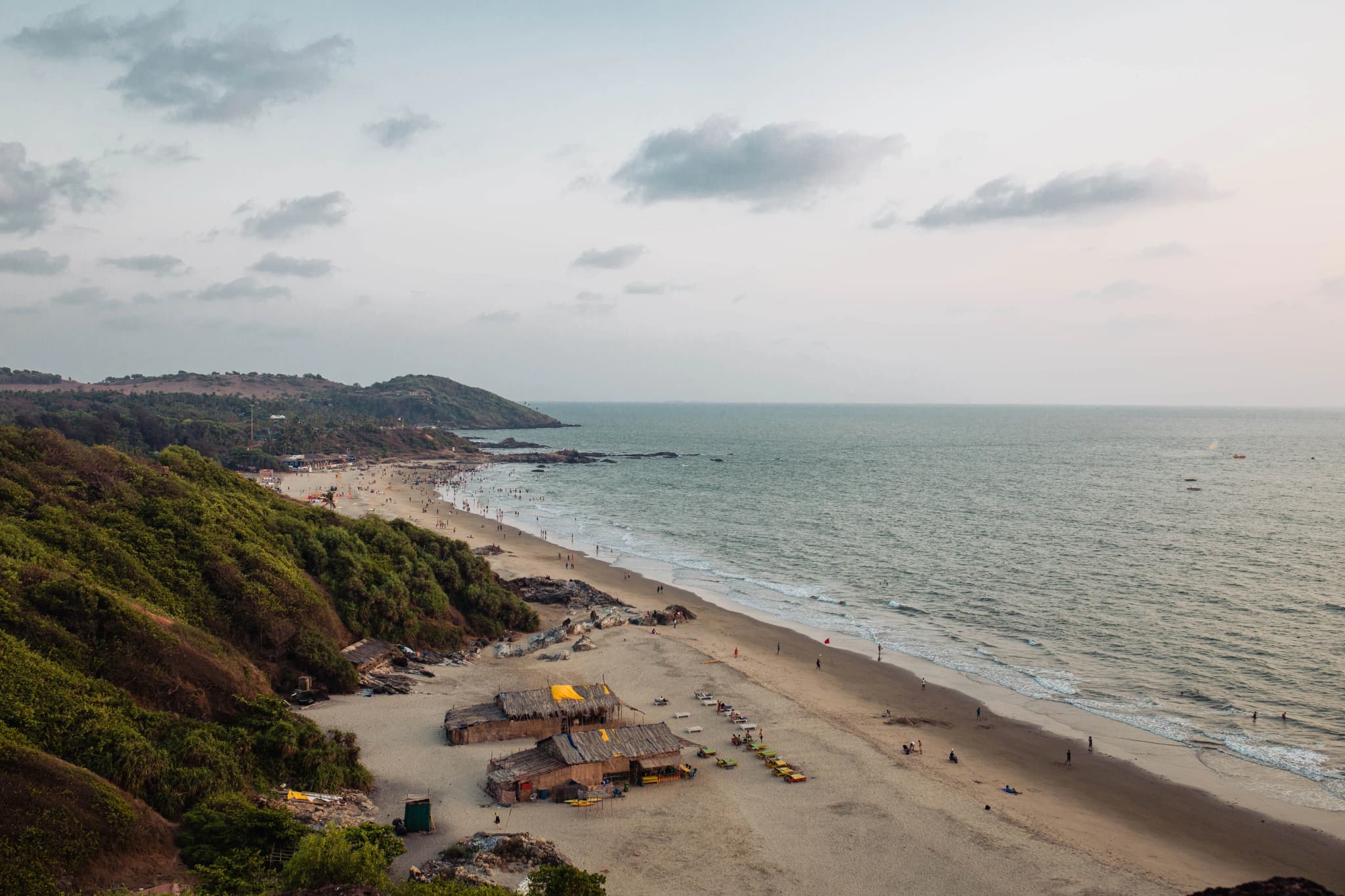 Scenic Goan beach with lush hills and gentle waves